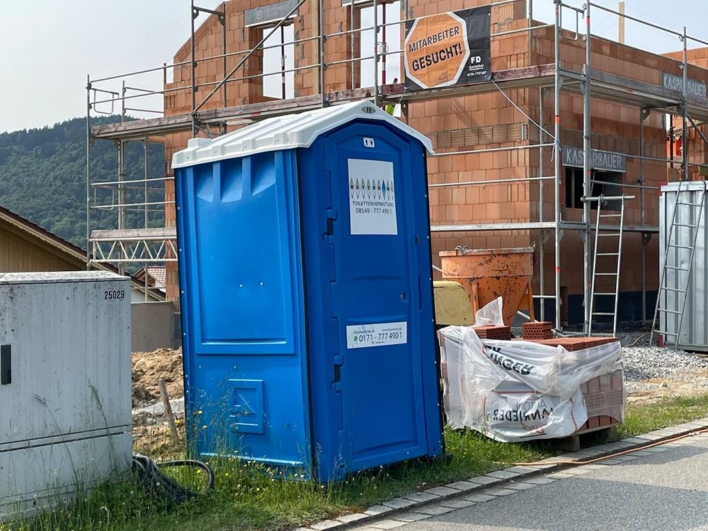 Blaues Bauklo neben baustelle am strassenrand Dixis f&uuml;r Bayern